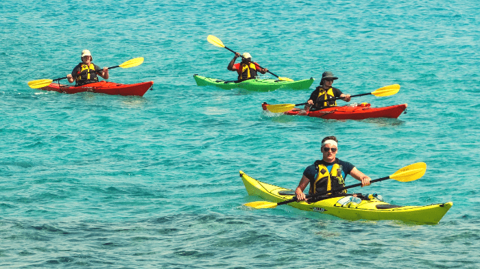 A group of people kayaking on a lake.