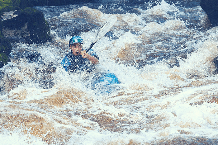 A man kayaking in rapids